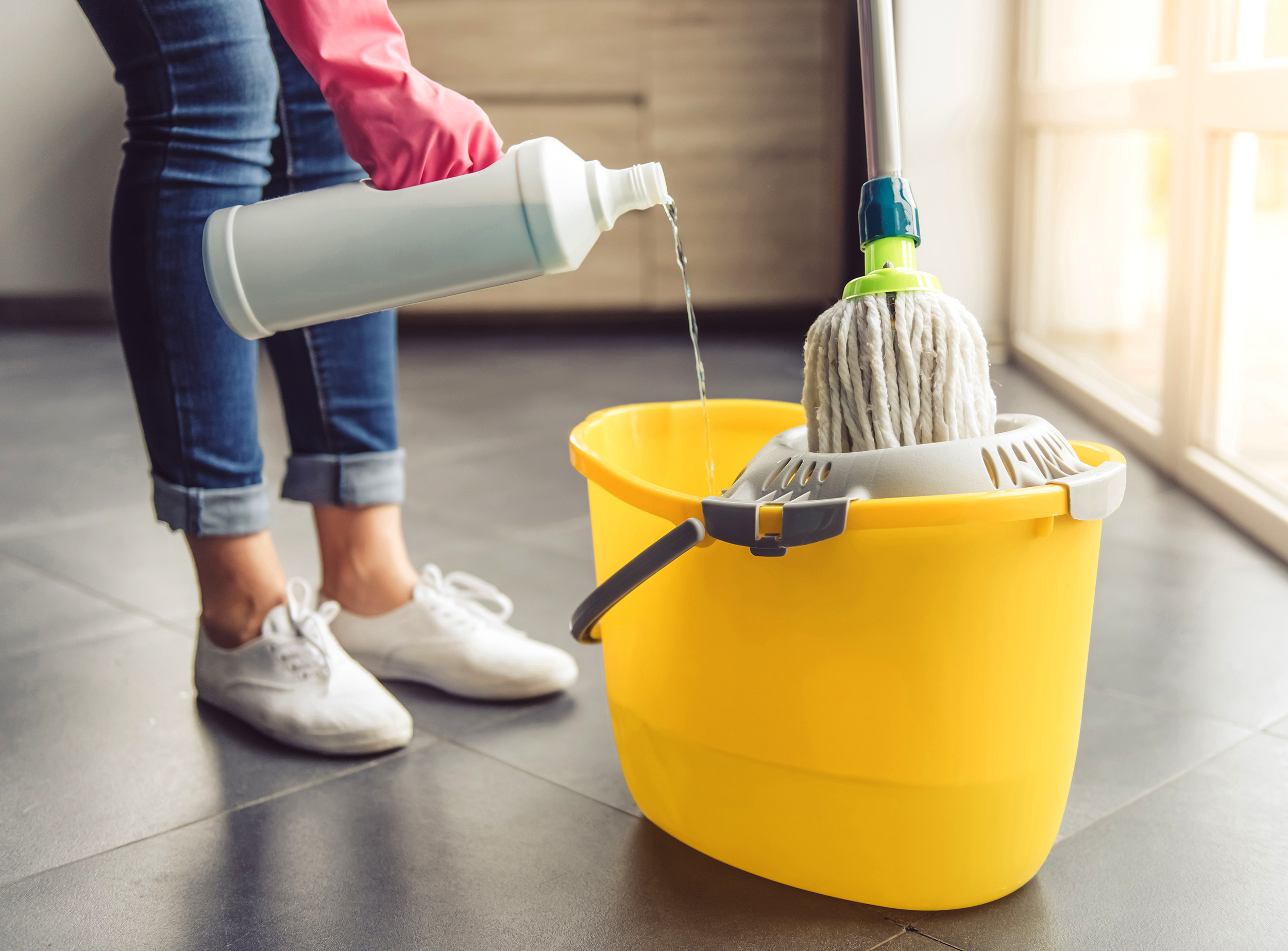 Cropped image of beautiful young woman in protective gloves pouring household chemical into the bucket and using a mop while cleaning floor in the house; Shutterstock ID 510917500; PO: TODAY